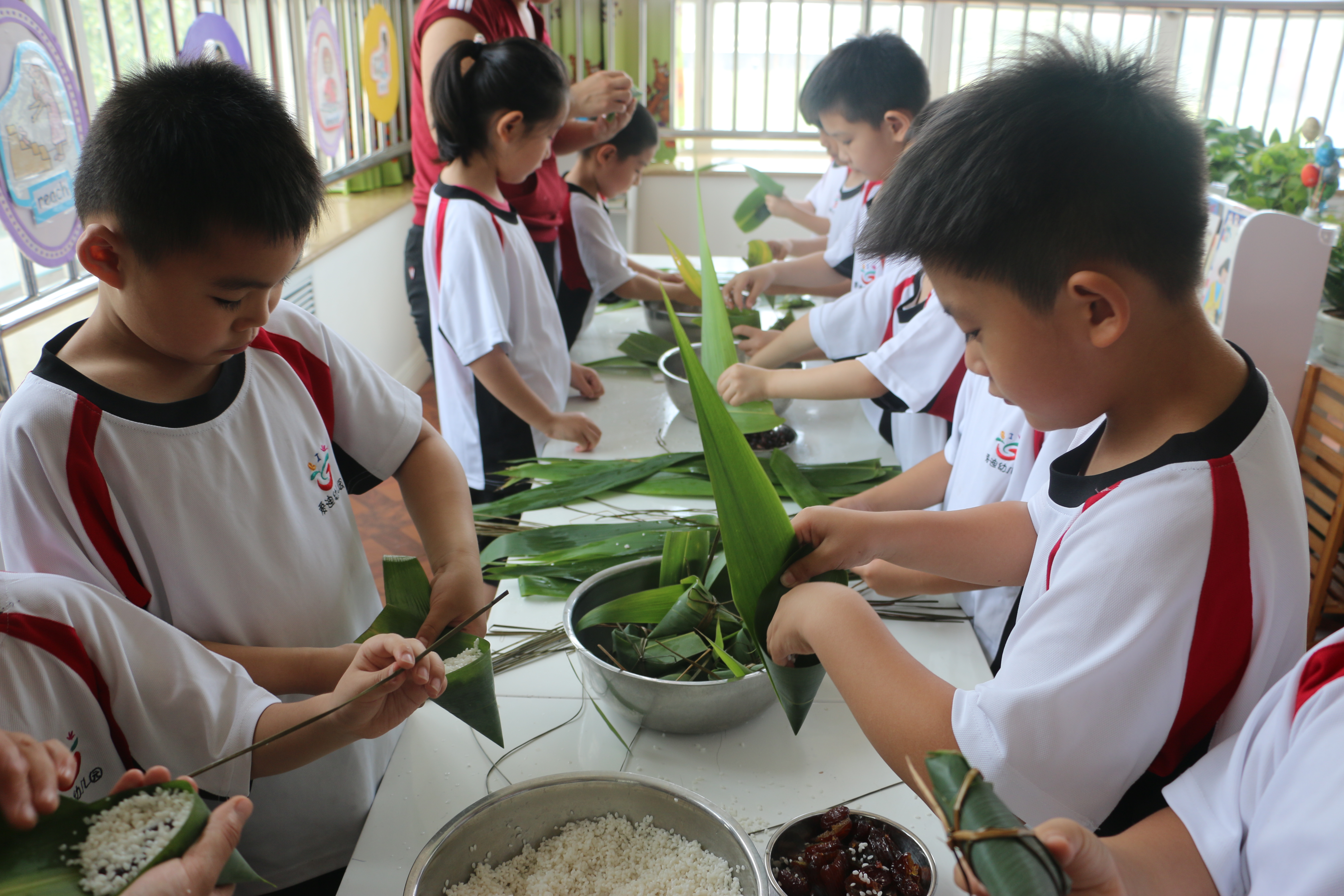 北京爱迪国际学校双语幼儿园的小朋友自己动手包粽子