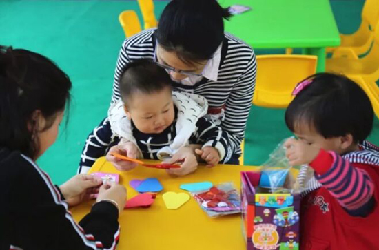 学乐星幼儿园老师协助小朋友制作风车、风铃