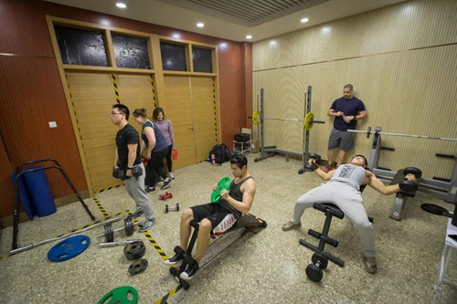 秦浩原和中外伙伴们一起在健身房里锻炼